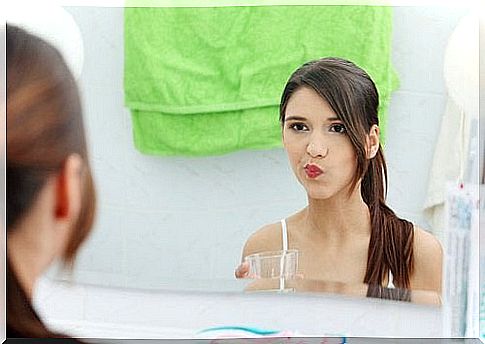 Woman rinsing mouth with apple cider vinegar