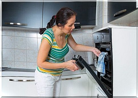 Woman taking the roasted sea bass to the oven