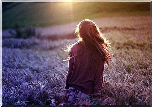 Woman walking in the field trying to overcome her pain.