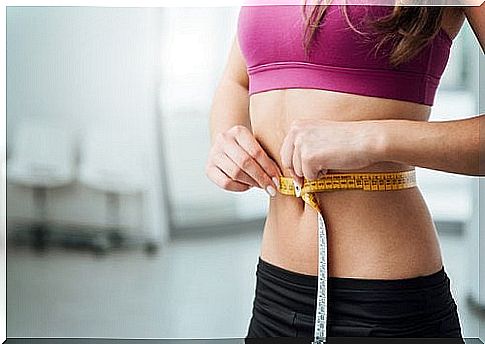 woman measuring her waist