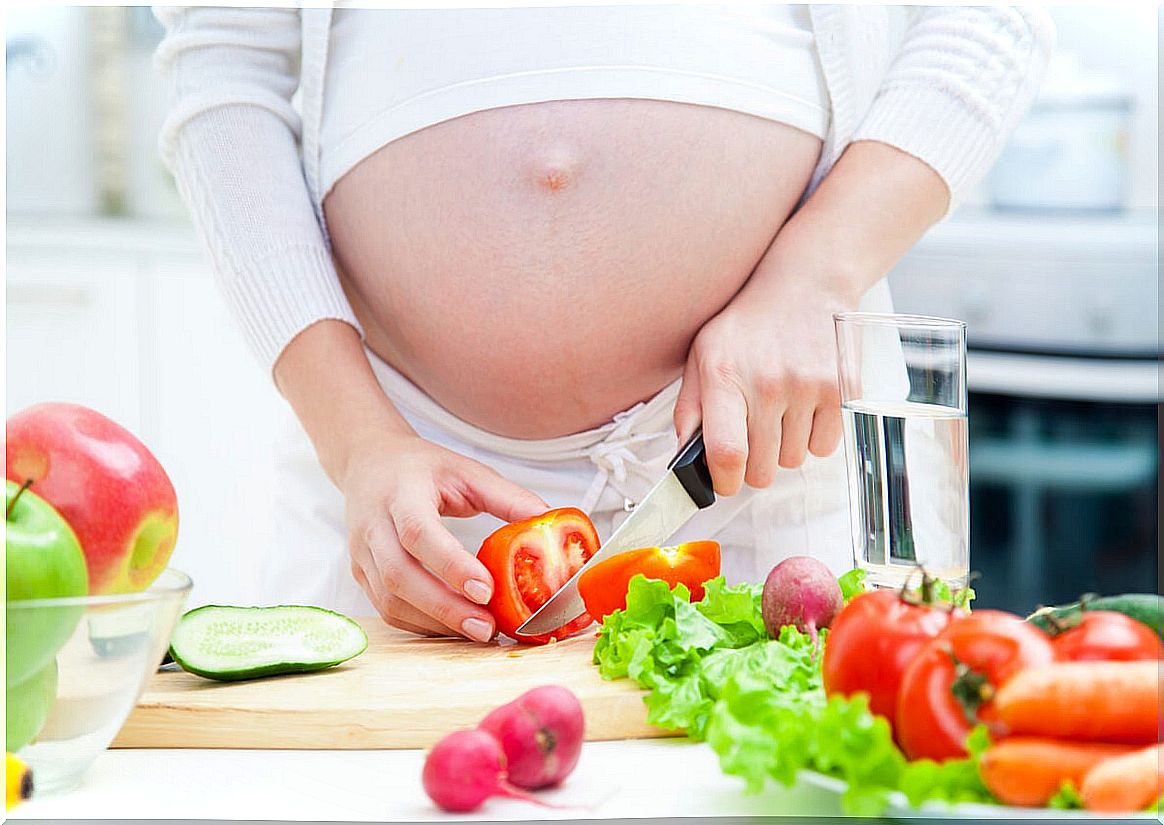 pregnant woman cutting salad