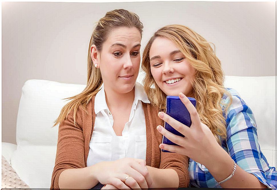 Mother checking daughter's cell phone to see social media